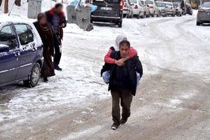 Tekerlekli sandalyesi olmadığı için sakat annesini sırtında taşıyor